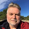 Mann i raud jakke tek selfie utandørs.