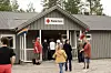 Folk står samla utanfor ein Røde Kors-bygning med norske flagg.