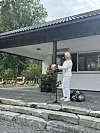 Kvinne står ved mikrofon utanfor ein kiosk.