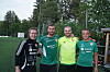 Fire menn står side om side utandørs i fotballdrakter.