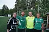 Fire menn står side om side utandørs i fotballdrakter.