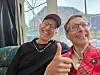 To menn på buss smiler, og den eine viser tommel opp.