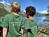 To barn står ved eit rekkverk og ser utover fjord og fjell.