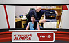 Mann står bak ei kvinne ved ei kontorpult i eit kontor.