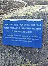 Blå minneplakett på ein stein med norsk og tysk tekst.