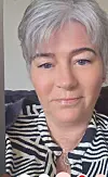 Nærbilete av ei kvinne med kort grått hår og stripete skjorte.