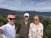 Tre personar står ute med fjord og fjell i bakgrunnen.
