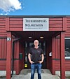 Ein mann står ved inngangen til Telemarkøye AS under eit skilt.