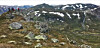 Turgåarar på ein fjellrygg med utsyn over eit snødekt fjellandskap.