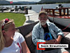 To personar sit ved ein båt ved fjorden.