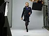 Ei kvinne går framover i eit fotostudio med lysutstyr på sidene.