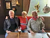 Tre menn sit ved eit bord på ein pub med eit glas øl framfor seg.