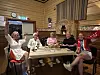 Fem personar sit ved eit bord og feirar innandørs.