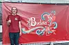 Mann i raud skjorte står framfor raudt Budeia-banner og viser tommel opp.