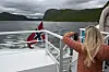 To personar på dekket ser ut over fjorden frå ein båt.