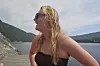 Ei kvinne står ved fjorden og ser ut over vatnet.