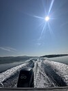 Båtsett bakfrå med kjølvasspor på fjorden under sola.