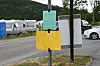 Handskrivne plakatar på ein stolpe ved ei vegkant.