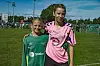 To ungdommar i fotballdrakter står på ein grasbane.