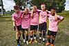 Fem fotballspelarar i rosa trøyer står saman på graset.