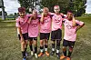 Fem fotballspelarar i rosa trøyer står saman på graset.