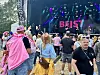 Festivalpublikum står framfor ei opplyst scene med skjermar og lys.