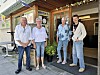 Fire personar står framfor ein butikk med blomster og planter.