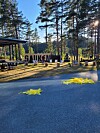 Uteområde ved skogsbilveg med store bokstavar og gule markørar på bakken.