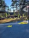 Uteområde ved skogsbilveg med store bokstavar og gule markørar på bakken.
