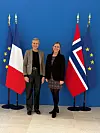To kvinner står framfor franske og britiske flagg.