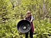 Person i skogen held ein stor, rund, svart gjenstand framfor seg.
