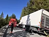 Person i raud vernebekledning ved ein kvit lastebil og eit raudt utrykkingskøyretøy.