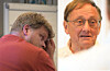 Samansett bilete av ein mann med handa mot ansiktet og ein eldre mann i portrett.