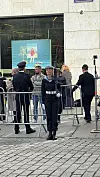 Uniformert personell står ved sperregjerde framfor ein inngang.