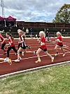 Ungdomar spring side om side på ein raud friidrettsbane.