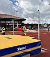Friidrettsutøvar hoppar over lista på ein utandørs stadion.