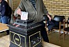 Person held ein lapp over ein svart, dekorert kasse i eit lokale.