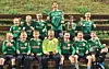 Ungdomslag i grøne fotballdrakter poserer samla utandørs.