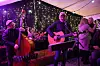 Musikarar spelar gitar og kontrabass på ei opplyst innandørsscene.