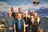 Ei gruppe personar står framfor fjell og ein flygande rovfugl.