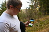 Person ser på ein smarttelefon i skogen.